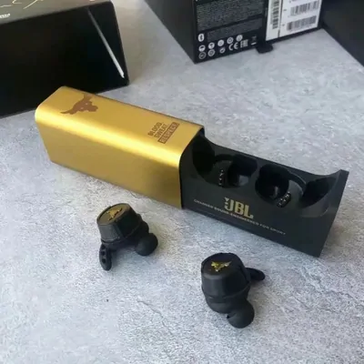 A pair of black wireless earbuds beside their charging case and a gold presentation box