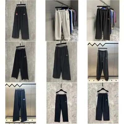 Six pairs of dark joggers and wide-leg trousers hanging on a chrome rail against a tiled wall