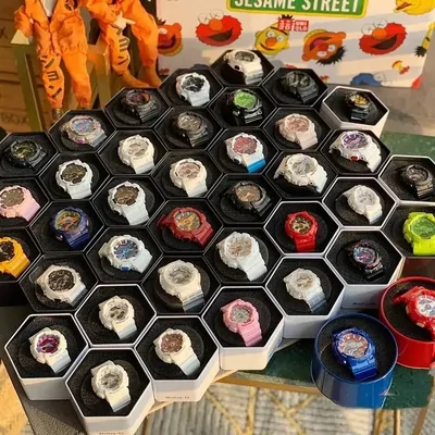 Dozens of wristwatches displayed face up in a honeycomb of hexagonal foam cells